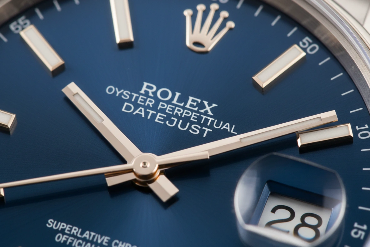 A close-up of a Rolex dial showing the flat-top 'A' and polished hour markers